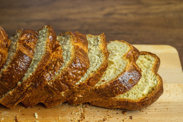 Sliced Brioche toast loaf with bread crumbs on wood cutting board	