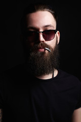 Obraz premium handsome bearded smoking man. Hipster boy