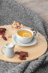 Top view of a cup of tea with lemon piece on wooden table