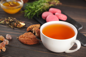 glass teapot with cup of black tea on wooden table