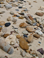 Fototapeta na wymiar Many gravel rocks lined the sand on the beach.