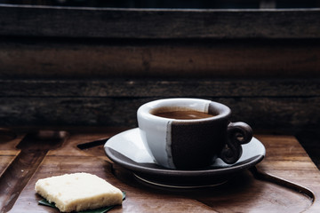 Espresso coffee in a black and white ceramic cup on wooden table at coffee shop. Drink photography concept, minimalism, close up