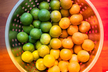 Green lemon lime or Thailand lemons on metal basket with orange light effect. Abstract of sweet, sour flavor and Thirsty.