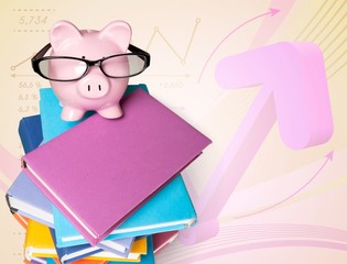 Piggy bank in glasses and books on white background