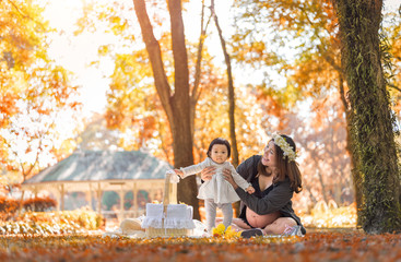 Pregnant women are resting with their daughters at the park.
