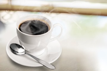 Coffee cup and spoon on wooden background