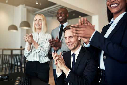 Smiling group of diverse businesspeople clapping after an office