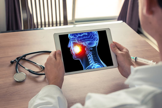 Doctor or dentist holding a digital tablet with 3D head and pain in the teeth and mouth