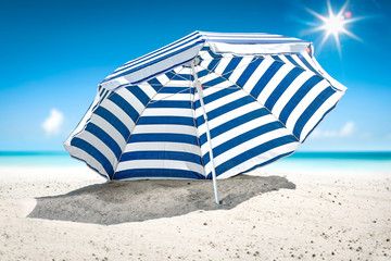 Summer background of umbrella with free space for your decoration on hot sand. Sunny day and ocean...