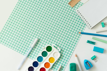 School supplies on white and blue checkered background