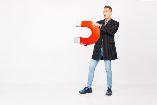 young man holding red horse shoe magnet attracting money and new customer, success business concept