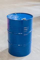 Vertical Photo Of A Blue Metal Oil Barrel On A Concrete Background.