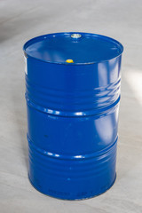 Vertical Photo Of A Blue Metal Oil Barrel Standing On A Concrete Floor.