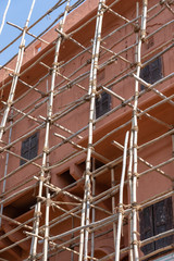 Bamboo scaffold on house, renovation. Scaffolding on building, pink wall and window. Jaipur, India
