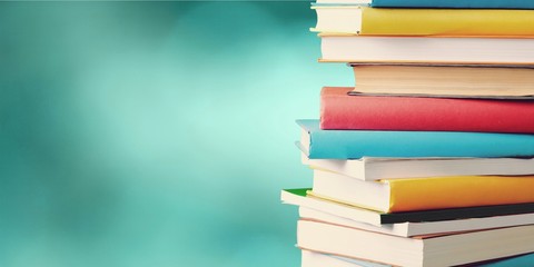 Stack of colorful books on blurred background