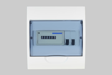 White plastic shield with electricity meter and circuit breakers for country house isolated on grey...