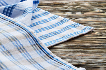 Old dark wooden background. Wooden table with blue and white kitchen towel
