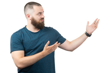 friendly young man pointing to his side and looking into the camera. isolated on white background