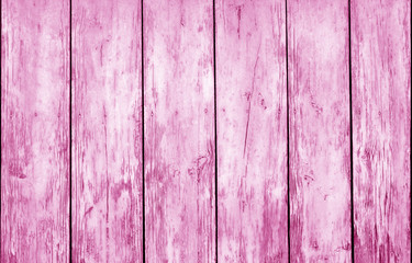 Weathered wooden fence in pink color.