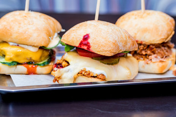 Close up three tasty burgers with different filling served on tray