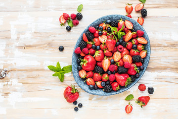 Draufsicht von frischen reifen Erdbeeren, von Blaubeeren und von Brombeeren auf Holztisch mit freiraumraum
