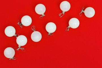 White christmas glass balls on red background. New Year eve decoration. Winter Holiday background with copy space. Flat lay. Top View.