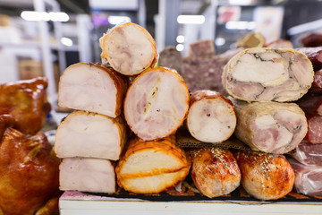 Variety of smoked and fried meat products. Traditional marketplace.