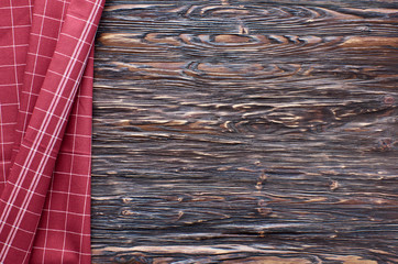 Old dark wooden background. Wooden table with red kitchen towel