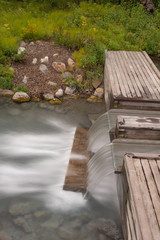 A portrait aspect of a long exposure of water tumbling down a step at the Liard Hot Springs, British Columbia, Canada, nobody in the image