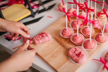 Raspberry keypops in the hands of the pastry chef