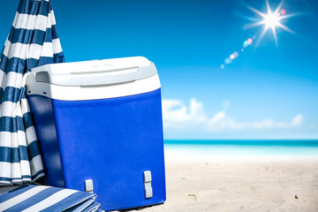 beach fridge on sand with umbrella and free space for your decoration. Summer landscape of ocean...
