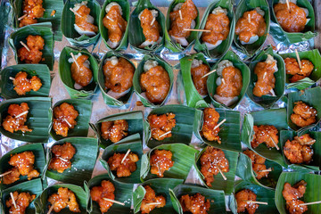 Fototapeta na wymiar Traditional indonesian snack in green palm leaves . Close up. Asian food background, buffet table