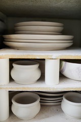 Fototapeta na wymiar Background image of handmade ceramic items on shelf in pottery workshop, copy space