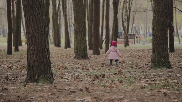 Beautiful little girl walking alone in the forest.