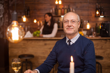 Portrait of nice old man smiling at the camera in a restaurant