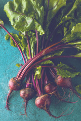 Großaufnahme von frischen reifen ungekochten roten Rüben (rote beete )auf blauer Oberfläche