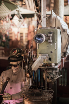 The old analog rotary film movie projector at outdoor cinema movies theater for show people in the Park with skeleton model in Halloween festival.