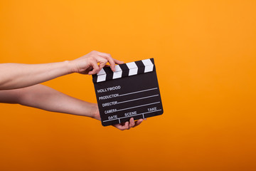 Photo of movie production clapper board isolated in studio over yellow background