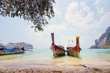 Beautiful landscape with traditional longtail boats, rocks, cliffs, tropical beach. Krabi, Thailand.