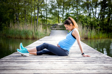 Pregnant woman exercising outdoor and resting