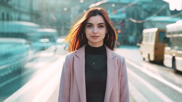 attractive european girl standing in the busy street between moving cars polluted air road traffic look camera time attack timelapse city slow fast motion