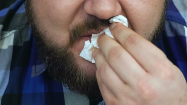 Fat man eats up the burger he made. Guy Wipes his mouth with a napkin. Unhealthy Lifestyle, fried and harmful high calorie food. The risk of obesity and overweight. Slow motion.