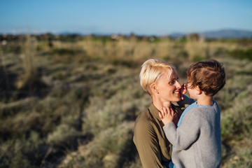 Portrait of young mother with small daughter in mediterranean nature.