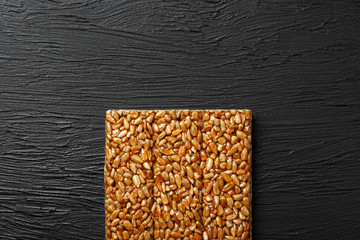Tile kozinaki from sunflower seeds on a black textural background. Delicious oriental sweets...