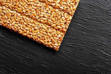 Tile kozinaki from sunflower seeds on a black textural background. Delicious oriental sweets...