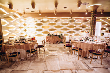 Wedding. Banquet. Beautiful and creative composition of a variety of pale pink flowers and candles that decorated the table for the newlyweds. Modern wedding decoration with geometric elements.