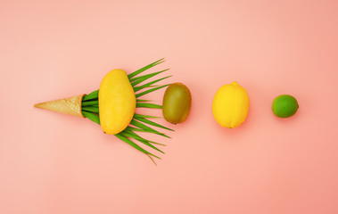 Table top view fruit tropical with spring summer holiday & vacation  background concept.Flat lay arrangement sliced various pineapple kiwi mango lemon and lime with ice cream cone on pink paper.