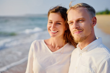 Obraz premium Love and romance. Honeymoon on the sea shore. Beautiful loving couple in white cloth on the beach.