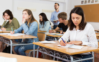 Fototapeta premium schoolgirl is sitting test and answer about task