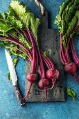 Großaufnahme von frischen reifen ungekochten roten Rüben (rote beete )auf blauer Oberfläche